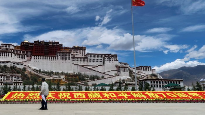 A man stands in front of a sign marking 70 years since Chinese rule over Tibet Credit Reuters Photo